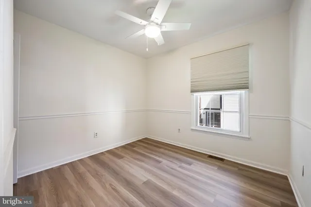 an empty room with a window and ceiling fan