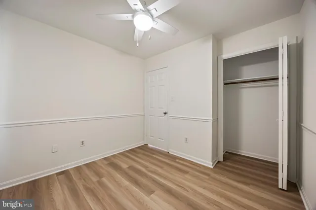 a view of a room with wooden floor and closet area