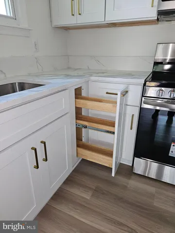 a kitchen with white cabinets and a wooden floor