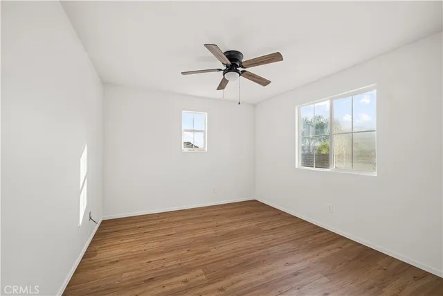 a big room with wooden floor and windows