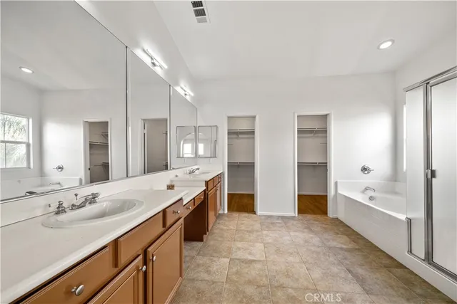 a view of a white house with a dry yard in front of it