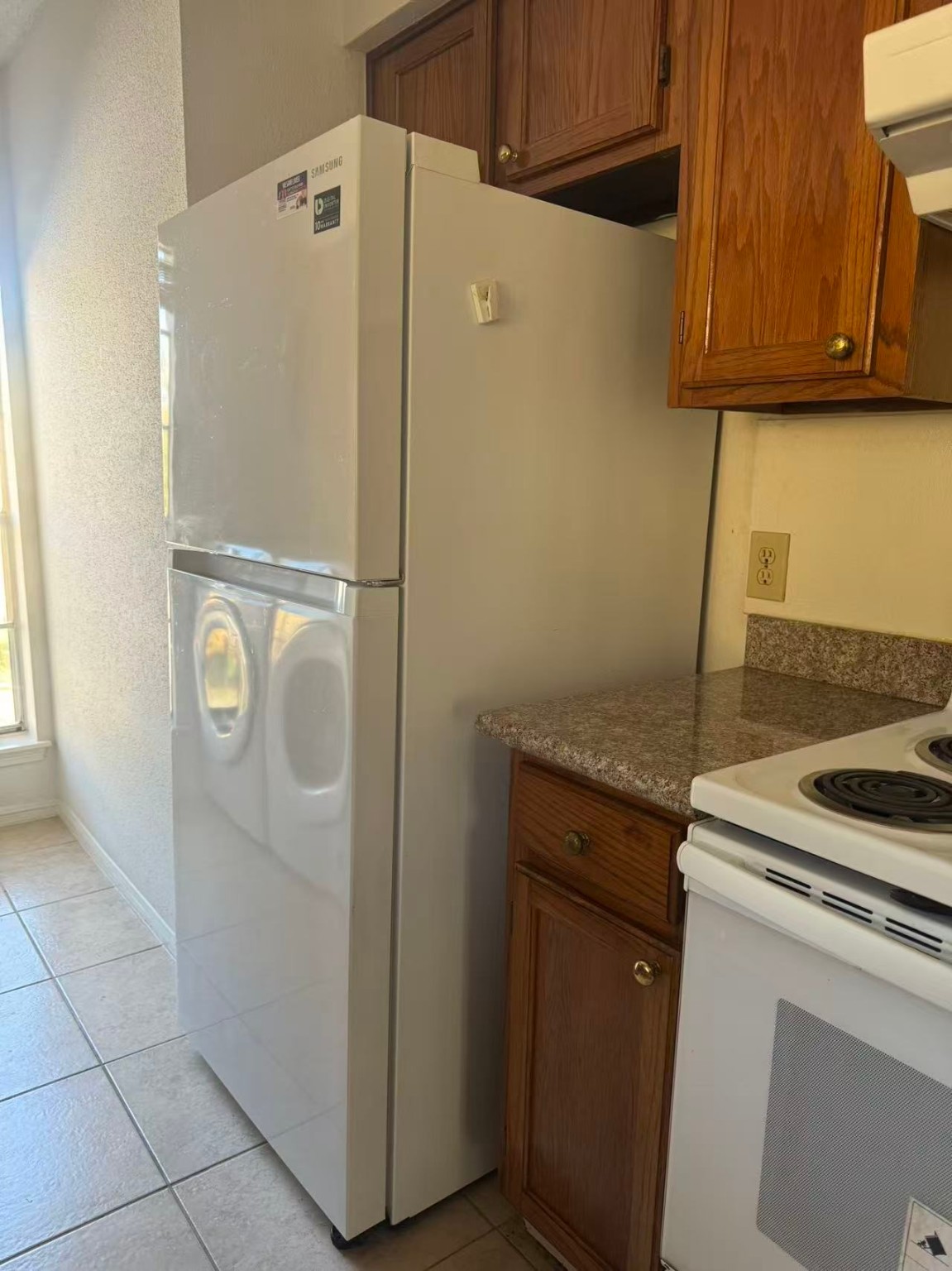 1515 Sandy Springs Road, Unit 2002 Houston, TX 77042 - Photo 13 of 19 a kitchen with a refrigerator and cabinets