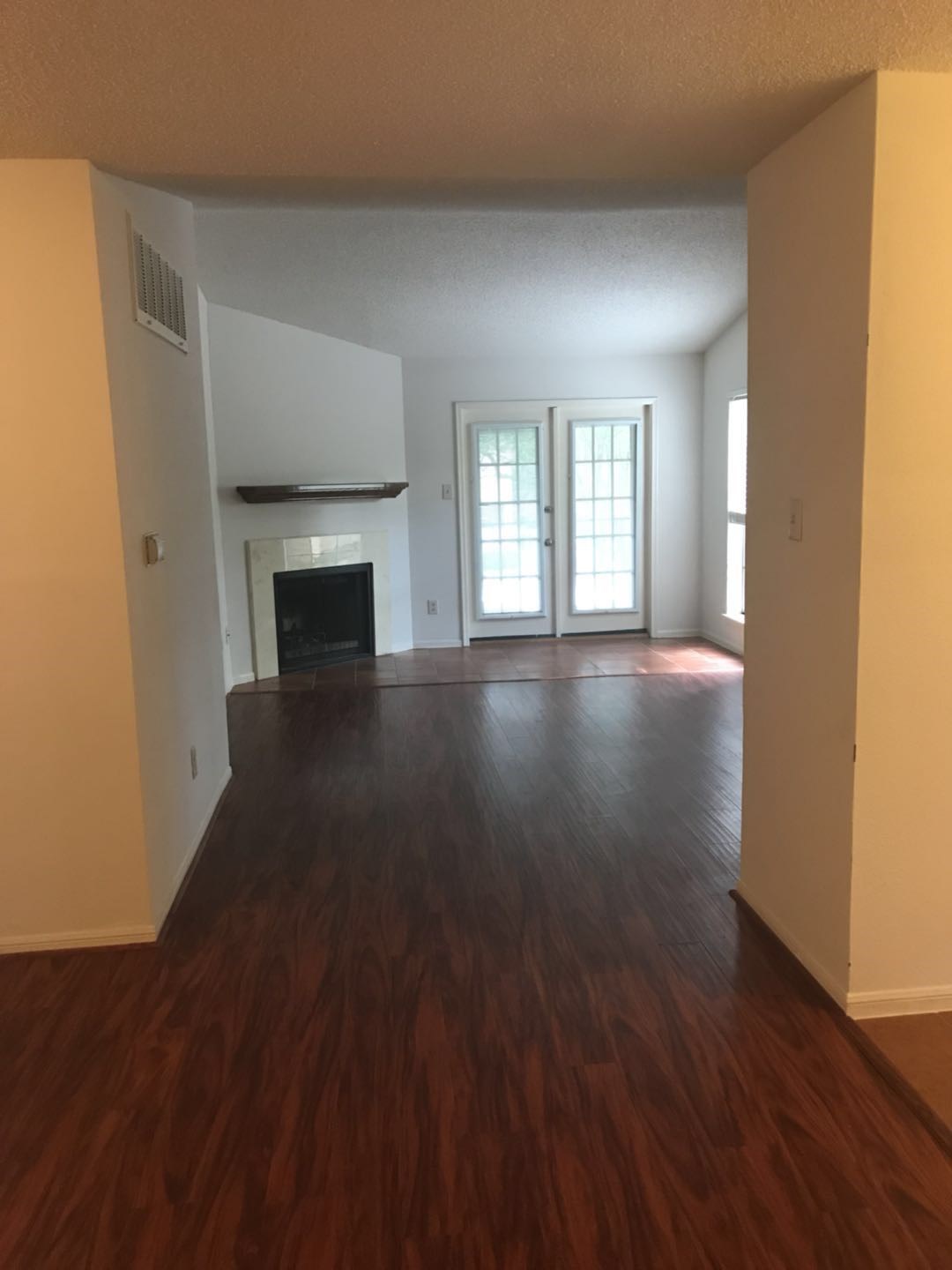 1515 Sandy Springs Road, Unit 2002 Houston, TX 77042 - Photo 5 of 19 an empty room with wooden floor fireplace and windows