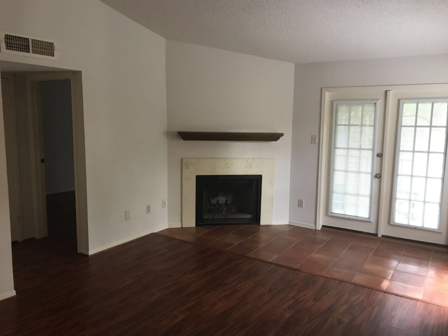 1515 Sandy Springs Road, Unit 2002 Houston, TX 77042 - Photo 6 of 19 a view of an empty room with wooden floor fireplace and a window