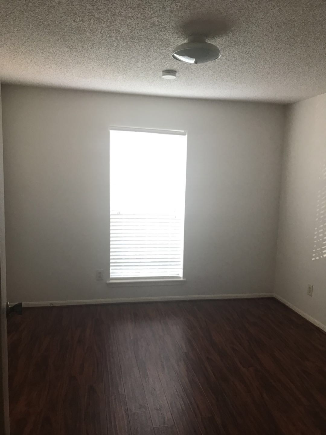 1515 Sandy Springs Road, Unit 2002 Houston, TX 77042 - Photo 7 of 19 an empty room with wooden floor and windows