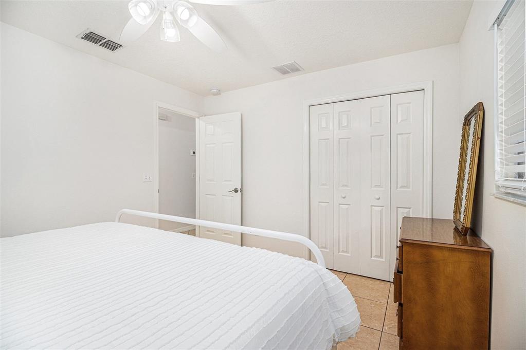 237 California Avenue St. Cloud, FL 34769 - Photo 14 of 26 a bedroom with a bed and a flat tv screen on dresser