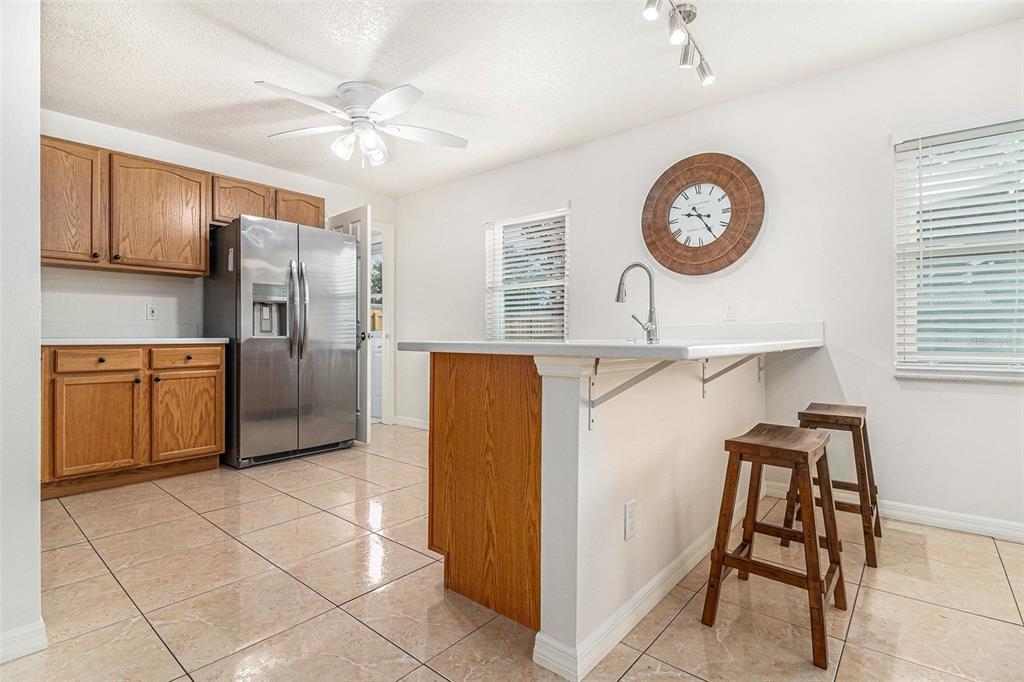 237 California Avenue St. Cloud, FL 34769 - Photo 10 of 26 a kitchen with stainless steel appliances granite countertop a refrigerator a stove top oven a clock and a window