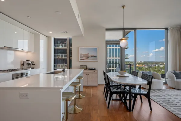 a dining room with furniture a chandelier and wooden floor