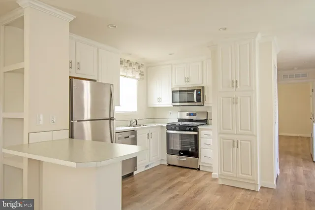 a kitchen with stainless steel appliances a refrigerator sink and stove