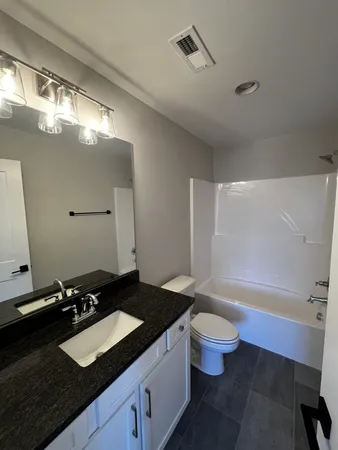 a bathroom with a sink a toilet a tub and a mirror