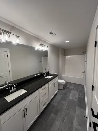 a large bathroom with a double vanity sink and mirror