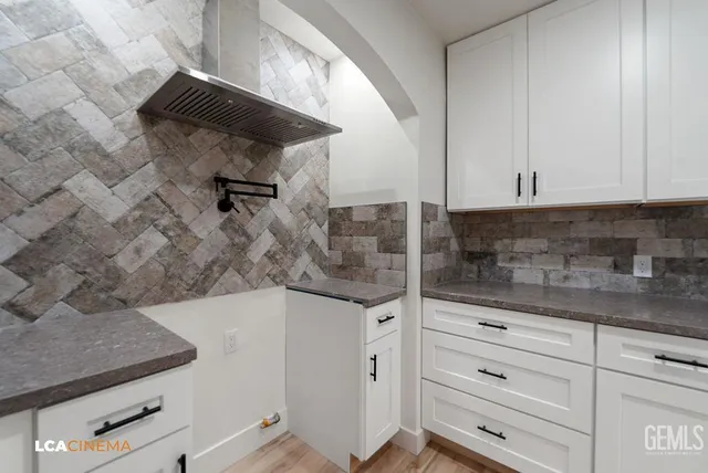 a large kitchen with stainless steel appliances granite countertop a sink and cabinets