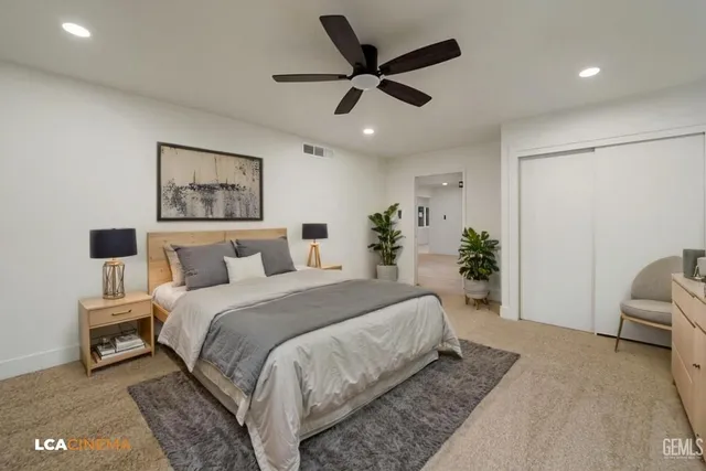 a bedroom with a bed a couch and a potted plant