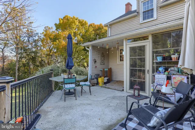 a view of a patio with table and chairs and wooden fence
