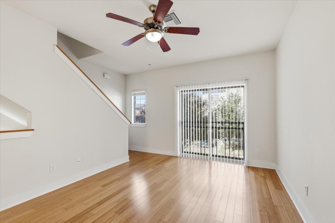 13420 Lyndhurst Street, Unit 807 Austin, TX 78717 - Photo 4 of 33 an empty room with wooden floor fan and windows