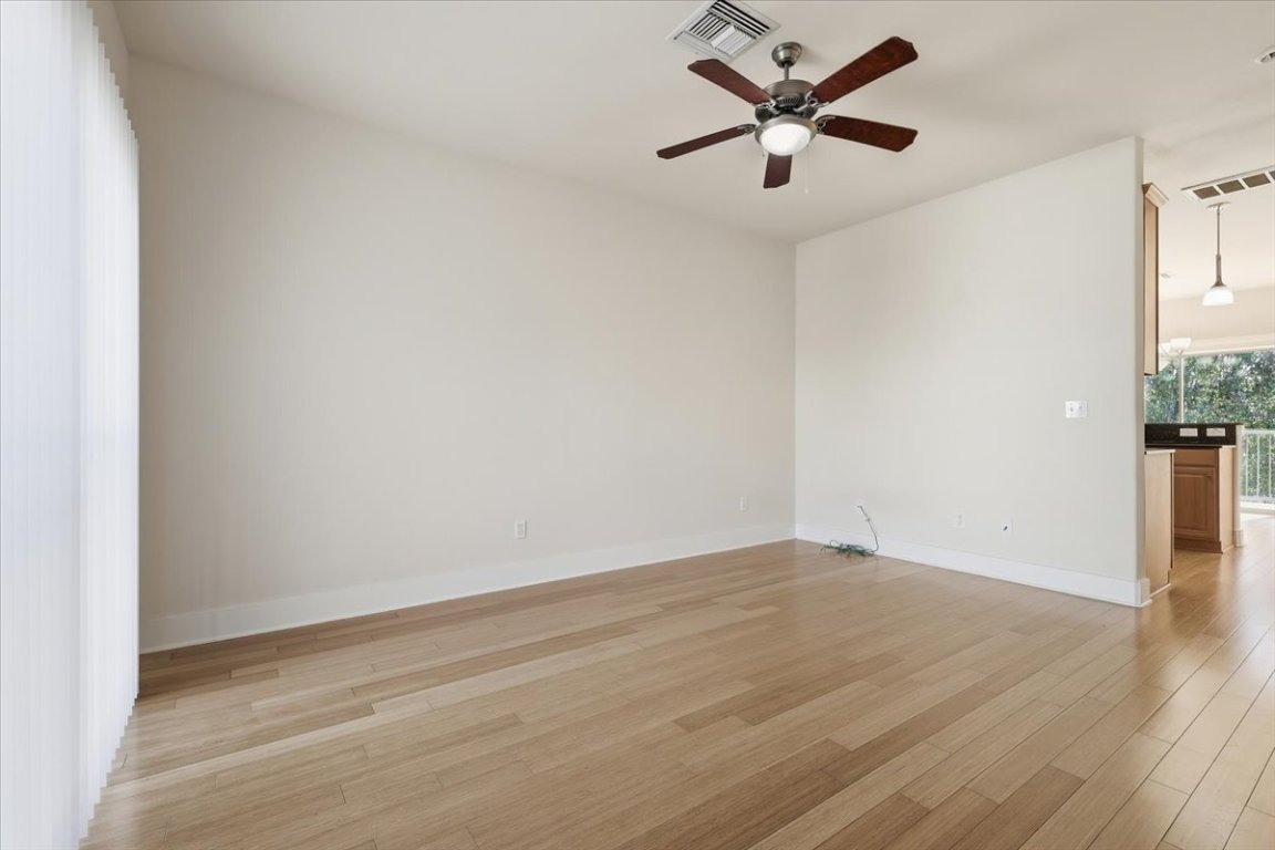 13420 Lyndhurst Street, Unit 807 Austin, TX 78717 - Photo 6 of 33 an empty room with wooden floor and a ceiling fan