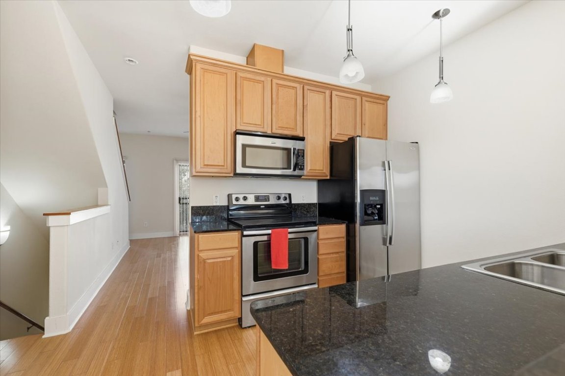 13420 Lyndhurst Street, Unit 807 Austin, TX 78717 - Photo 7 of 33 a kitchen with stainless steel appliances granite countertop a refrigerator a stove top oven a sink and dishwasher