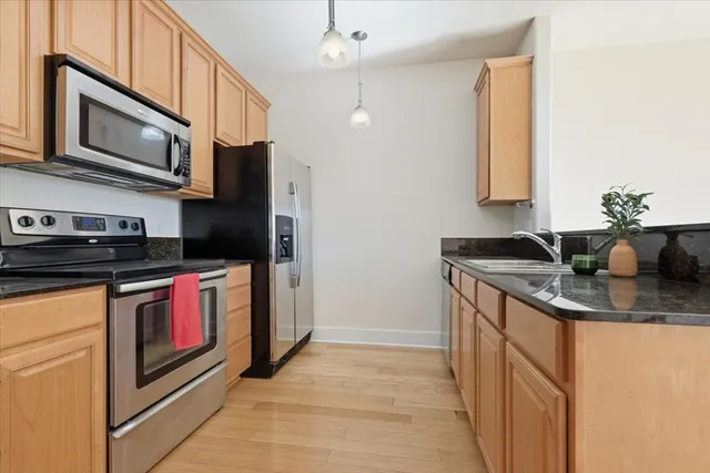 a kitchen with stainless steel appliances granite countertop a sink and a stove