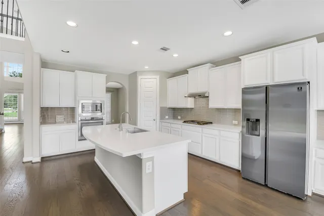 a kitchen with stainless steel appliances a refrigerator sink and cabinets