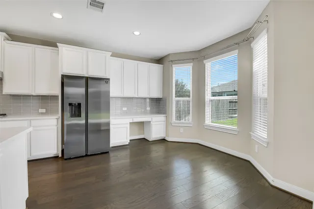 a kitchen with a refrigerator a sink dishwasher with a stove and cabinets with wooden floor