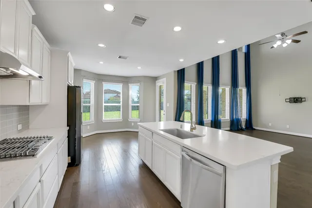 a kitchen with sink stove and refrigerator