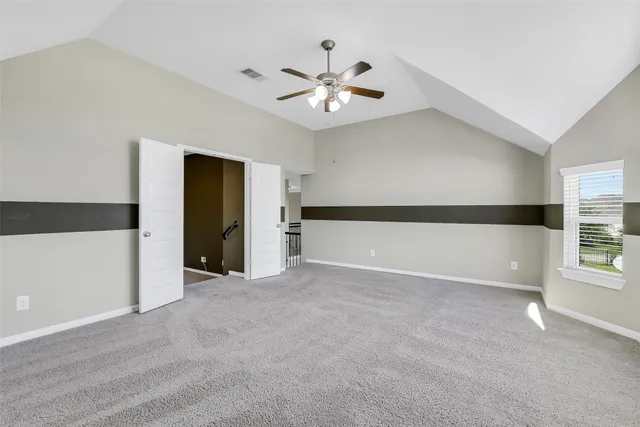 en empty room with a ceiling fan and a window