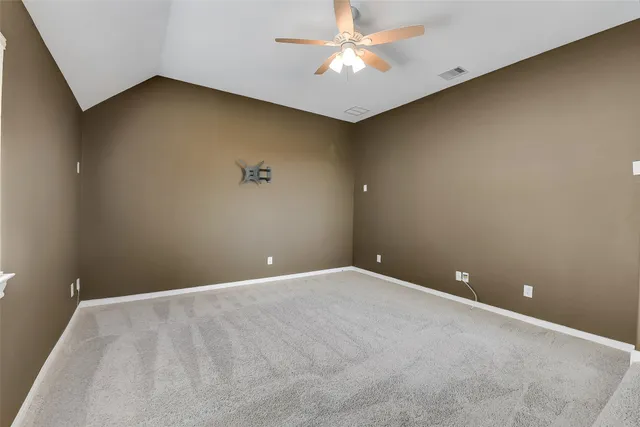 an empty room with closet and a chandelier fan