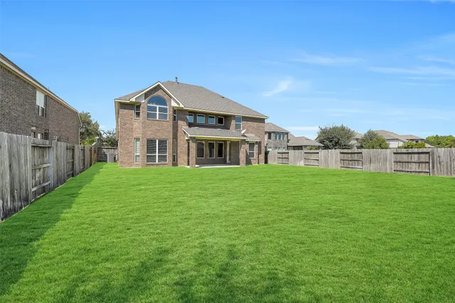 a view of yard with swimming pool and green space