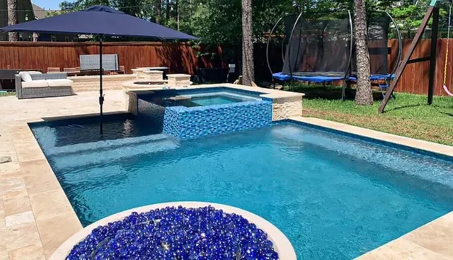 a view of swimming pool with lawn chairs wooden floor and fence