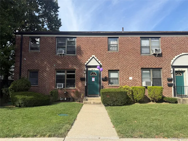 a front view of a house with a yard and porch