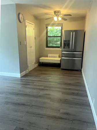 a view of a refrigerator in kitchen and an empty room