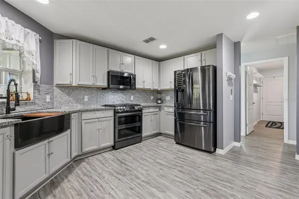 a kitchen with a refrigerator stove and wooden cabinets