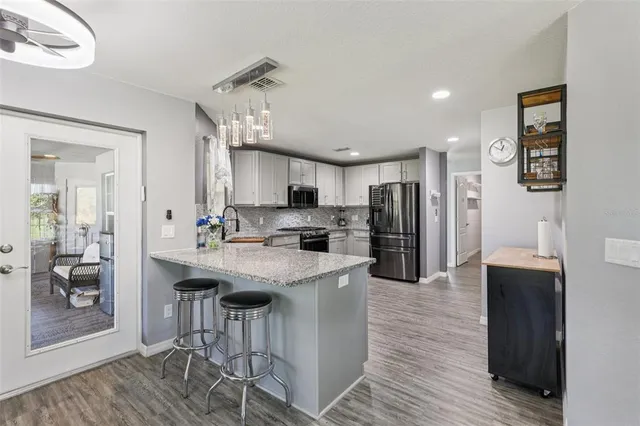 a kitchen with stainless steel appliances kitchen island granite countertop a refrigerator and a stove top oven