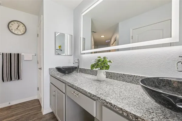 a bathroom with a granite countertop sink and a mirror