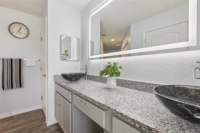 a bathroom with a granite countertop sink and a mirror