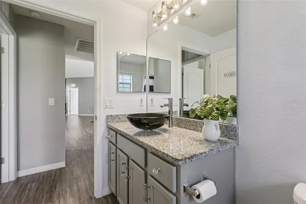 a bathroom with a granite countertop sink and a mirror