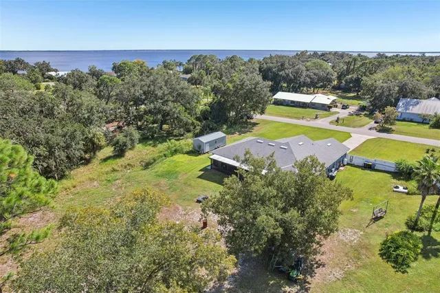 an aerial view of residential houses with outdoor space and trees