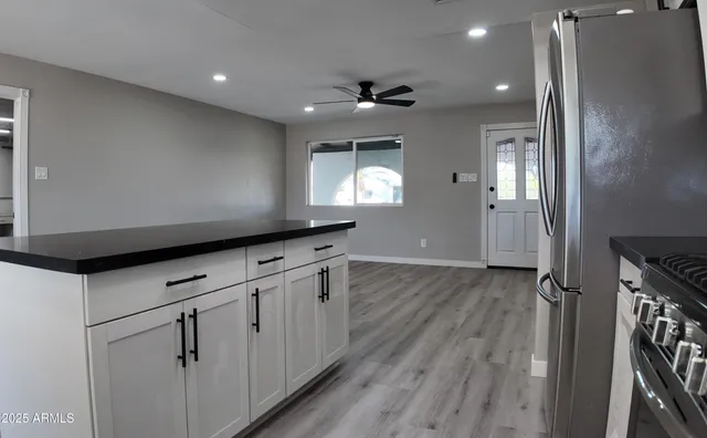 a kitchen with granite countertop white cabinets and white appliances
