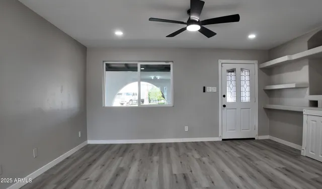 a kitchen with a white cabinets and wooden floor