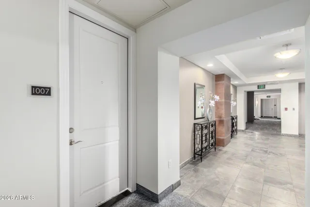 a view of a hallway with furniture and a refrigerator