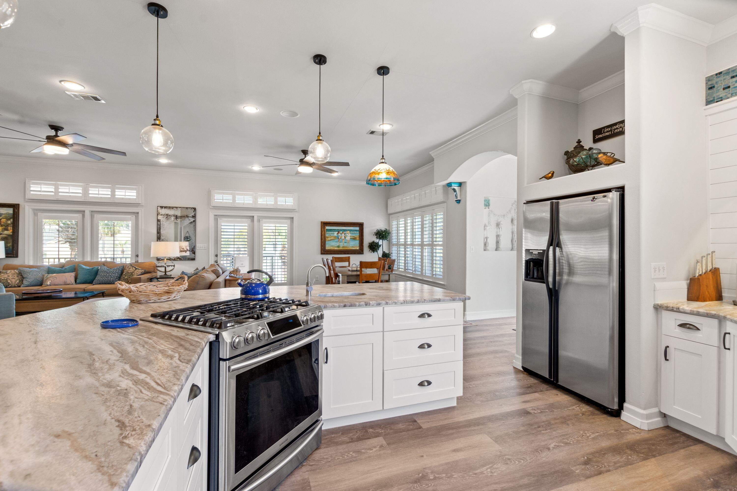 100 Sandprint Circle Destin, FL 32541 - Photo 8 of 62 a kitchen with stainless steel appliances granite countertop a stove a refrigerator a sink a oven and a refrigerator with wooden floor