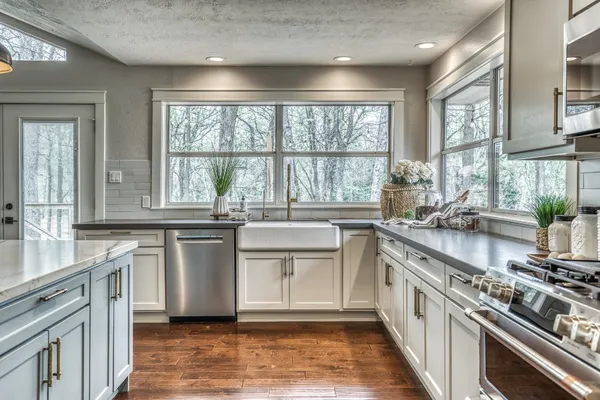 a large kitchen with stainless steel appliances granite countertop a stove a sink and a microwave