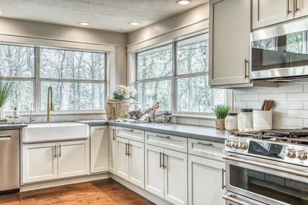 a kitchen with stainless steel appliances white cabinets and a window