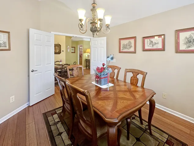 a view of a dining room with furniture a chandelier and wooden floor