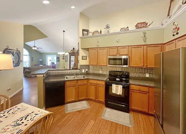 a kitchen with stainless steel appliances granite countertop a refrigerator a stove and a sink