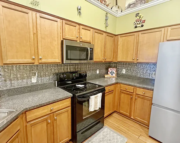a kitchen with stainless steel appliances granite countertop a sink stove and microwave
