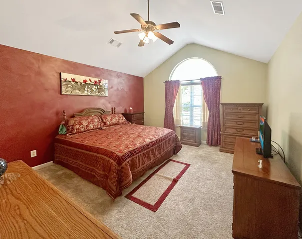 a bedroom with a bed and dresser with mirror