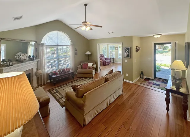 a living room with furniture and a wooden floor
