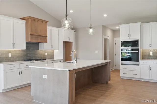 a kitchen with kitchen island a sink stainless steel appliances and cabinets
