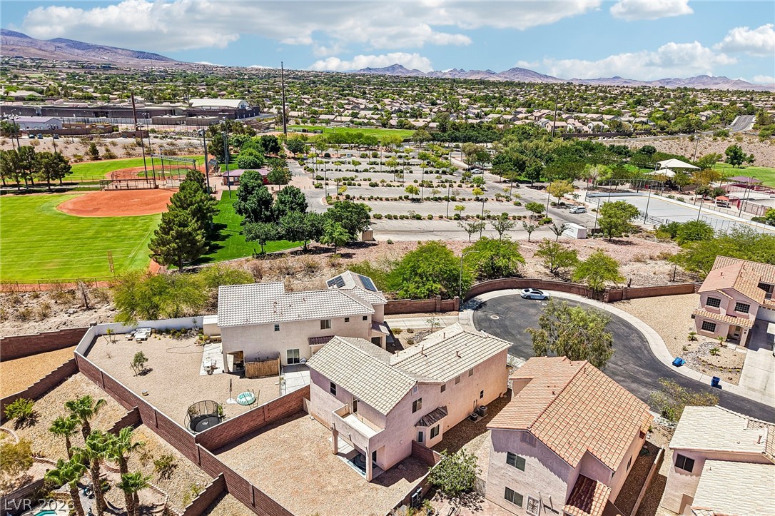 1176 Butternut Ranch Court Henderson, NV 89052 - Photo 51 of 60 An aerial perspective showcases homes nestled against a verdant sports field and distant mountain ranges.